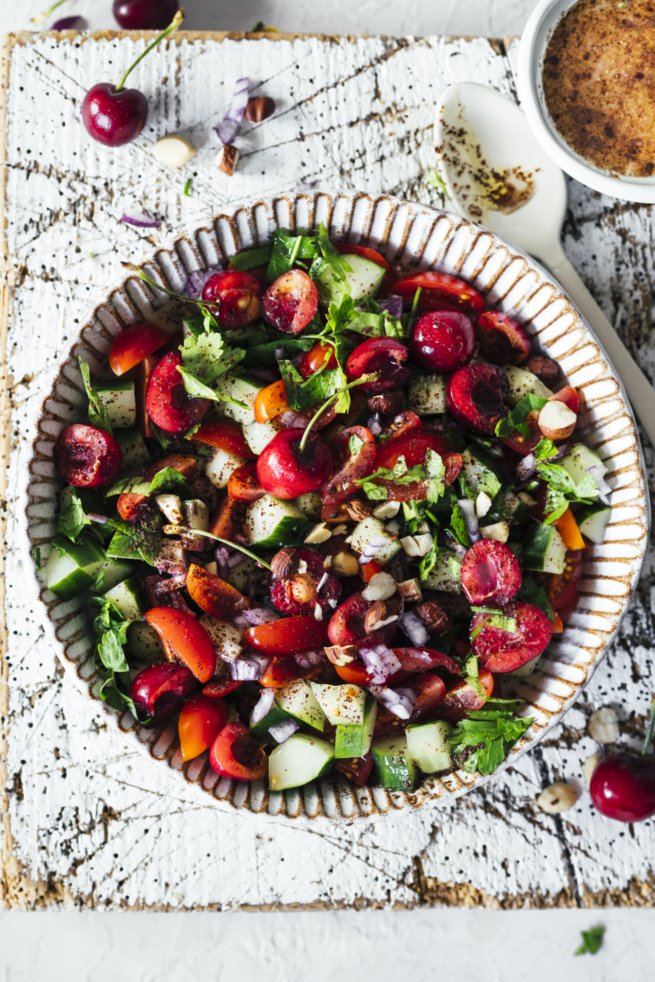 Bunter, veganer Tomaten Gurken Salat mit Sumach Kirsch Dressing